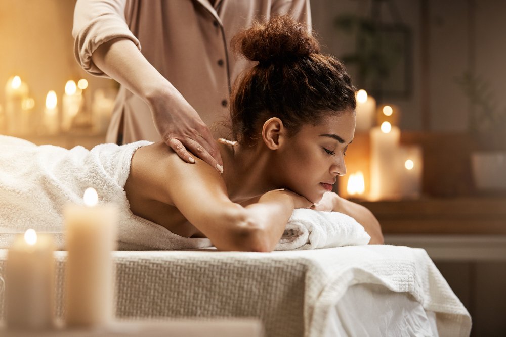 tender-african-woman-smiling-enjoying-massage-with-closed-eyes-spa-resort